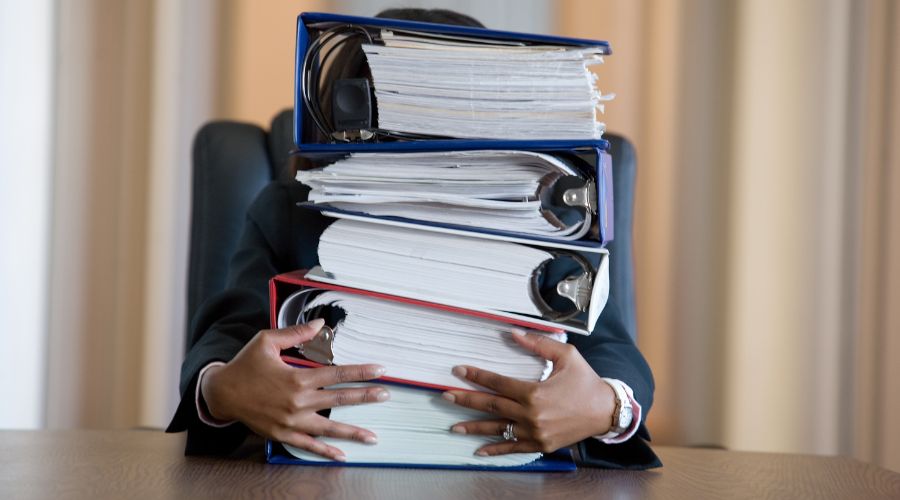Office worker holding stack of binders